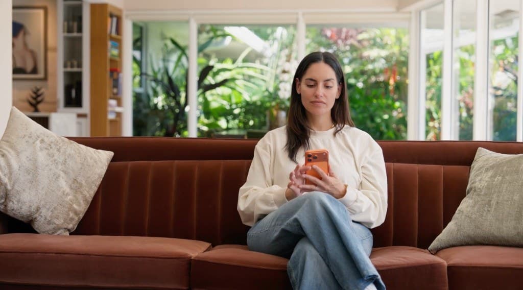A woman on a couch browsing TestWell panels on her phone